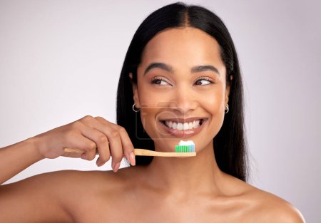 Photo for Happy woman, toothbrush and teeth for dental, cleaning or hygiene against a grey studio background. Face of female person with bamboo tooth brush for clean oral, mouth and gum healthcare or wellness. - Royalty Free Image