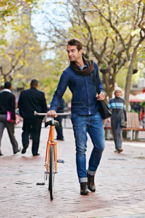 Téléchargez les photos : Se déplacer dans la voie verte. Plan complet d'un bel homme dans la ville avec son vélo - en image libre de droit