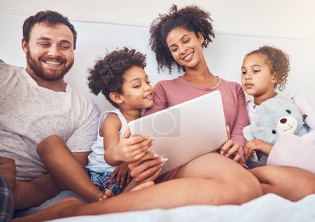 Photo for Bed, tablet and happy family streaming, movies or games while bonding, relax and play in their home. Online, subscription and children with parents in a bedroom for entertainment, fun and watching. - Royalty Free Image