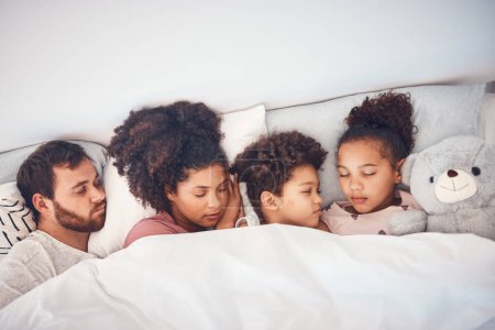 Photo for Sleeping, above and family in a bed with love, dreaming and resting in their home cosy together. Sleep, top view and children with parents in a bedroom nap, peaceful and hugging, comfort and bond. - Royalty Free Image