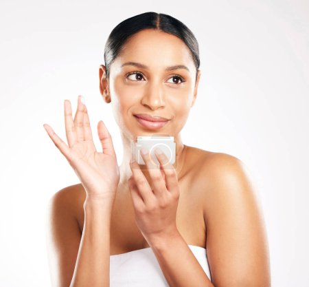 Photo for Woman, face and cream for skincare, beauty or cosmetics against a white studio background. Female person or model with container product, lotion or creme and smile for dermatology or facial treatment. - Royalty Free Image