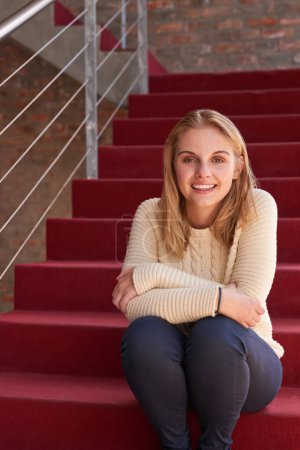 Photo for Campus life. Portrait of a university student sitting on a staircase at campus - Royalty Free Image