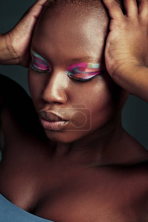 Photo for Why fit in when you were born to stand out. Cropped shot of a beautiful woman wearing colorful eyeshadow while posing against a grey background - Royalty Free Image