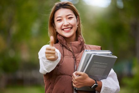 Photo for Student, thumbs up and portrait of woman with books for learning, education and outdoor on university campus with happiness or pride. Happy, face and girl in college with notebook or walking to class. - Royalty Free Image