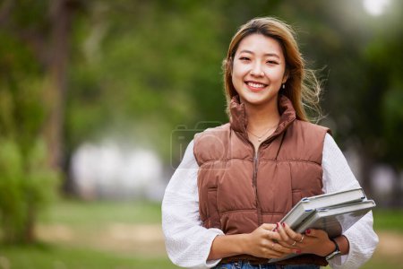 Photo for Asian student, portrait and woman with books for learning, education and outdoor on university campus with happiness or pride. Happy, face and girl in college with notebook or walking to class. - Royalty Free Image