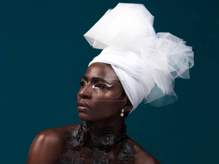 Téléchargez les photos : 100 vraie beauté. Plan studio d'une jolie jeune femme posant en tenue traditionnelle africaine sur fond bleu - en image libre de droit