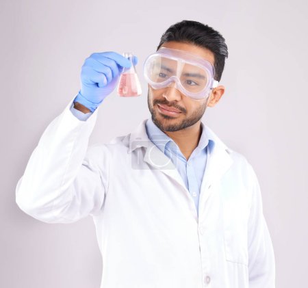 Photo for Scientist man, studio and beaker with goggles, thinking or analysis for focus by white background. Asian science expert, glass container and chemistry innovation with idea, ppe or study at pharma job. - Royalty Free Image