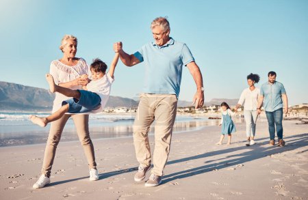 Photo for Swinging, grandparents and a child walking on the beach on a family vacation, holiday or adventure in summer. Young boy kid holding hands with a senior man and woman outdoor with fun energy or game. - Royalty Free Image