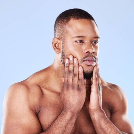 Photo for Cosmetics, self care and black man with skincare, luxury and grooming against a blue studio background. Male person, model or guy with treatment, shine and glow with dermatology, thinking or wellness. - Royalty Free Image