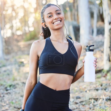 Photo for Fitness, nature or portrait of happy woman drinking water in training, running exercise or workout for wellness. Runner, bottle or healthy sports girl on break in park with smile or music headphones. - Royalty Free Image