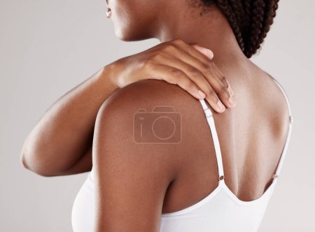 Foto de Mujer africana, dolor de espalda y lesiones con problemas de salud, tensión muscular e inflamación en un fondo de estudio gris. Persona femenina, dolor corporal o modelo con tensión articular, dolor e hinchazón por el estrés. - Imagen libre de derechos