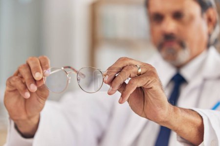Photo for Optometrist, man and glasses in hand for vision or eyesight or prescription lens for worker. Doctor, closeup and frames in workplace with eyewear for wellness or focus with medical expert for care - Royalty Free Image