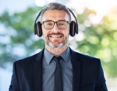 Photo for Face, mature and business man with headphones outdoor for music podcast. Portrait, accountant and happy ceo listening to radio, audio or hearing sound with smile for jazz, hip hop and song on bokeh - Royalty Free Image