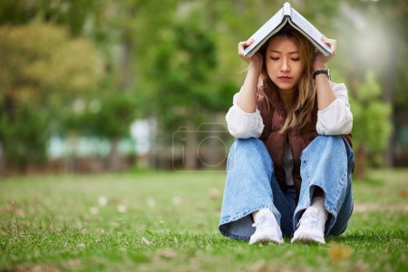 Photo for Study, sad and book with woman in park for studying, thinking or depression mockup. College, mental health and education with asian student on grass in nature for burnout, anxiety and fatigue problem. - Royalty Free Image