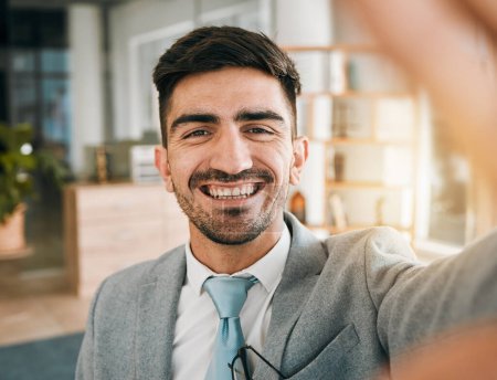Téléchargez les photos : Visage d'homme d'affaires, selfie et sourire dans le bureau moderne avec confiance, fierté et bonheur pour les entrepreneurs en démarrage. Photographie numérique, portrait et homme heureux dans un état d'esprit professionnel sur le lieu de travail - en image libre de droit