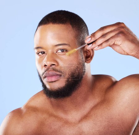 Photo for Man, portrait or face oil in studio, aesthetic skincare or beauty dermatology on blue background. Serious black male model, facial cosmetics or dropper of hyaluronic acid, collagen or vitamin c serum. - Royalty Free Image