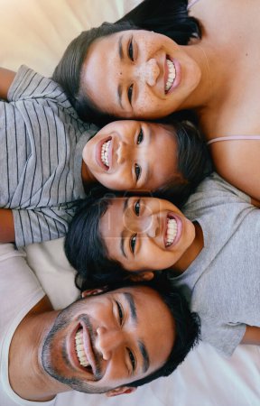 Photo for Portrait, smile and above asian family in bed, relax and having fun while bonding in their home. Top view, love and face of children with parents in bedroom, happy and resting together on the weekend. - Royalty Free Image