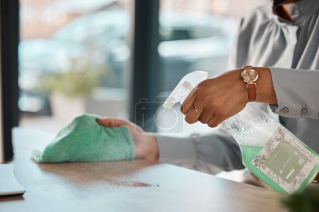 Photo for Hands, cleaning and product on a wooden table for hygiene, disinfection or to sanitize a surface in a home. Gloves, bacteria and spray with a woman cleaner in the living room for housework or chores. - Royalty Free Image