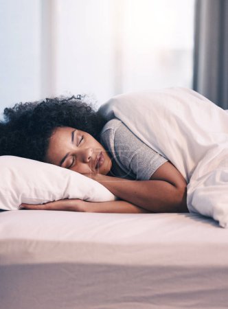 Téléchargez les photos : Sommeil, femme africaine et lit avec sieste matinale à la maison avec repos se sentant calme avec paix. Maison, chambre et femme fatiguée se détendre et confortable sur un oreiller avec couverture rêvant le week-end. - en image libre de droit