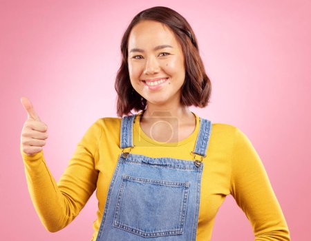 Photo for Happy, thumbs up and yes with portrait of woman in studio for support, agreement and motivation. Winner, emoji and success with person on pink background for achievement, thank you and vote sign. - Royalty Free Image