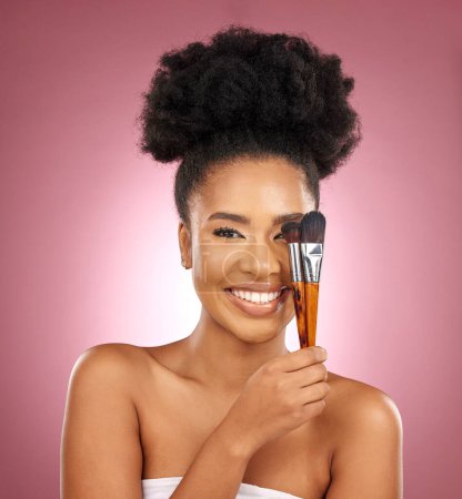 Photo for Portrait, makeup and black woman with brushes, skincare and dermatology against a pink studio background. Female person, aesthetic or model with cosmetic tools, natural beauty or shine with self care. - Royalty Free Image