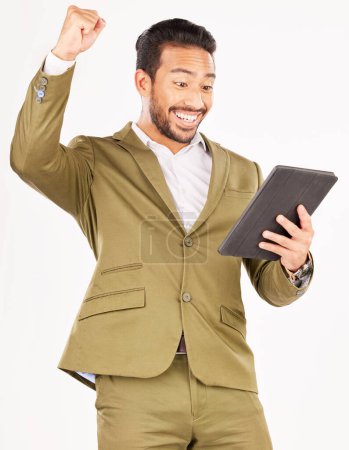 Photo for Happy asian man, tablet and fist pump in celebration for winning, discount or sale against a white studio background. Excited businessman with technology in success for good news, bonus or promotion. - Royalty Free Image