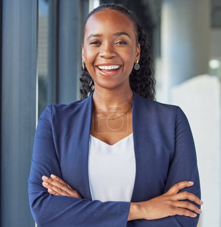 Foto de Retrato, sonrisa y brazos cruzados con una mujer negra de negocios de pie en su oficina profesional. Corporativa, liderazgo y confianza con una gestora feliz en el lugar de trabajo para el empoderamiento. - Imagen libre de derechos