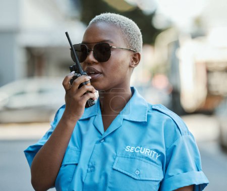 Photo for Woman, radio and a security guard or safety officer outdoor on a city road for communication. Black person talking on walkie talkie on urban street to report crime for investigation and surveillance. - Royalty Free Image