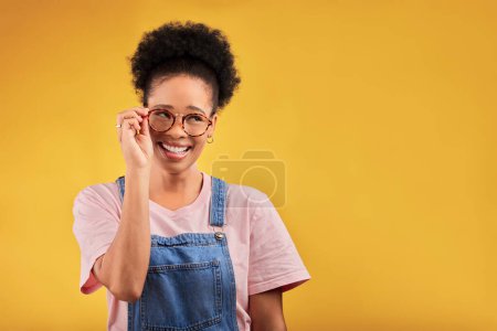 Photo for Smile, glasses and vision with a black woman nerd on a yellow background in studio for style. Fashion, eyewear and a happy young afro female geek at the optometrist for prescription frame lenses. - Royalty Free Image