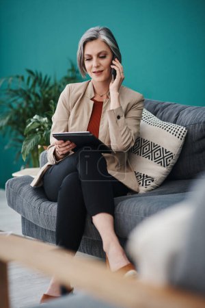 Photo for Run the stats by me again. Cropped shot of an attractive mature businesswoman sitting alone and using technology in her home office - Royalty Free Image