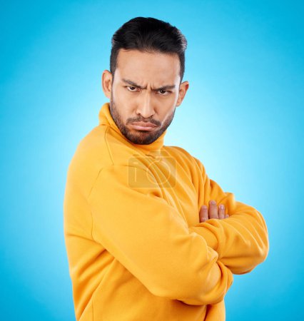 Photo for Portrait, frown and asian man with arms crossed in studio angry, frustrated and annoyed on blue background. Conflict, anger and face of Japanese male with defensive body language, denial or offended. - Royalty Free Image