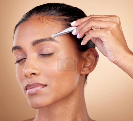 Photo for Beauty, studio or woman face with tweezers for eyebrow maintenance, hair removal or morning facial cleaning. Self care product, eyes closed or relax spa person with grooming tools on brown background. - Royalty Free Image
