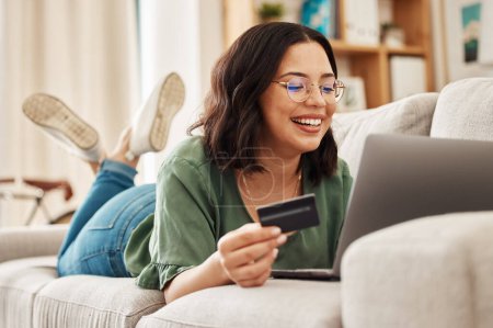 Photo for Relax, laptop and credit card, happy woman on couch in living room for internet banking in home for online shopping. Ecommerce payment, smile and cashback, girl on sofa with computer and website sale. - Royalty Free Image