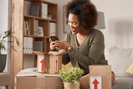 Photo for Boxes, phone and woman unboxing for online shopping, courier service and product review on social media. Cardboard package, e commerce and happy african person or influencer on mobile at home on sofa. - Royalty Free Image