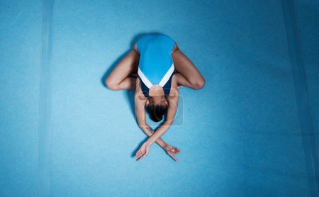 Photo for Top view, gymnast and woman stretching for performance on ground with mockup space. Sports, gymnastics and athlete training, dance and exercise for fitness, healthy body and wellness for workout. - Royalty Free Image