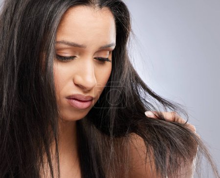 Photo for Hair tips, damage and woman in studio with worry for split ends, haircare crisis and weak strand. Beauty, hairdresser and face of sad female person with frizz, dry and loss problem on gray background. - Royalty Free Image