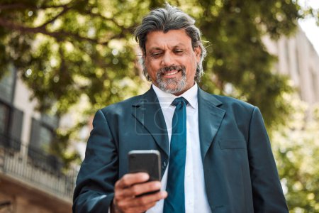 Photo for Senior businessman, phone and texting in street with smile, thinking and communication on internet. Mature entrepreneur man, smartphone and networking with web chat, social media and contact on app. - Royalty Free Image