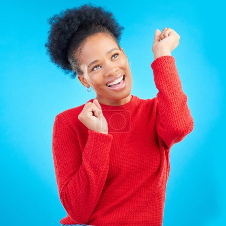 Photo for Happy woman, fist pump and celebration for winning, discount or sale against a blue studio background. Excited female person for good news, bonus promotion or lottery prize in reward or competition. - Royalty Free Image