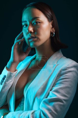 Photo for Neon, beauty and portrait of woman in studio with blue light for stylish, classy or formal fashion. Style, cosmetic and young Asian female model with makeup and fancy blazer by dark black background - Royalty Free Image