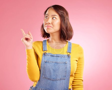 Photo for Asian woman, smile and hand pointing to studio for news, announcement or coming soon deal on pink background. Finger, show and Japanese lady with timeline, checklist or sign up, promo or contact info. - Royalty Free Image