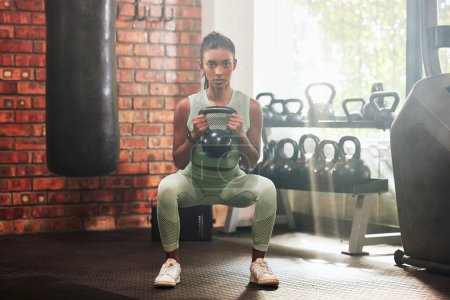 Photo for Fitness, kettlebell and portrait of a woman in the gym doing strength legs and arms training. Sports, exercise and serious female athlete doing a strong squat workout with a weight in a sport center - Royalty Free Image