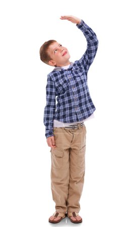 Photo for Isolated boy kid, check height and smile for growth, development and thinking by png background. Male child model, young and happy with hand for measuring, think and childhood wish with kids fashion. - Royalty Free Image