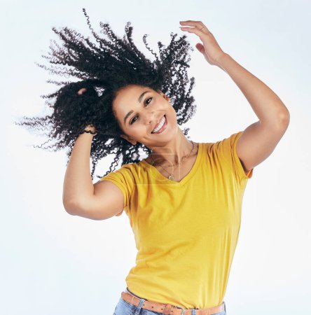 Téléchargez les photos : Cheveux, danse et portrait d'une femme à la coiffure afro, sourire et mode isolés dans un fond blanc studio. Sourire, décontracté et jeune avec des vêtements élégants ou à la mode heureux pour la liberté. - en image libre de droit