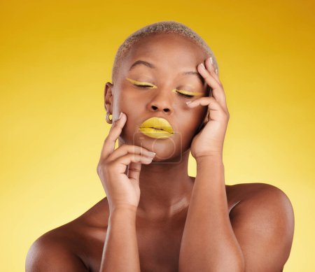 Photo for Creative, makeup and face with lipstick or black woman in studio on a yellow background for art, beauty or cosmetics. Gold, color and eyeshadow on calm model with eyes closed for fashion or aesthetic. - Royalty Free Image