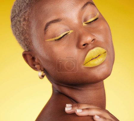 Photo for Cosmetic, art and woman in a studio with makeup eyeliner and lipstick for cosmetology. Beauty, creative and young African female model with a colorful glamour face routine by a yellow background - Royalty Free Image