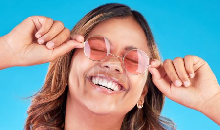 Photo for Fashion sunglasses, face and happy woman in studio isolated on a blue background. Smile, glasses and Indian model with style, casual shades and positive mindset for aesthetic, gen z and eyes closed. - Royalty Free Image