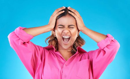 Photo for Angry, frustrated and a shouting woman on a blue background with a anger about mental health. Stress, bipolar and a young screaming Indian girl with a fail or mistake isolated on a studio backdrop. - Royalty Free Image