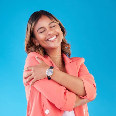 Photo for Professional, hug and business woman in studio for self love, support and care with confidence. Corporate, happy and female person embrace for positive mindset, pride and happiness on blue background. - Royalty Free Image