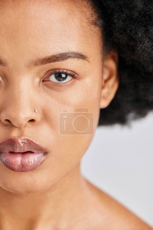 Téléchargez les photos : Beauté, portrait en studio et femme africaine avec brillance de soin, maquillage de fond de teint et cosmétiques naturels pour une peau éclatante. Gros plan demi-visage, oeil et personne avec bien-être auto-soin sur fond blanc. - en image libre de droit