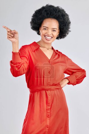 Photo for Pointing, portrait and black woman with a smile, promotion and presentation against a white studio background. Happy, female person or model with hand gesture, happiness or discount deal with a sale. - Royalty Free Image